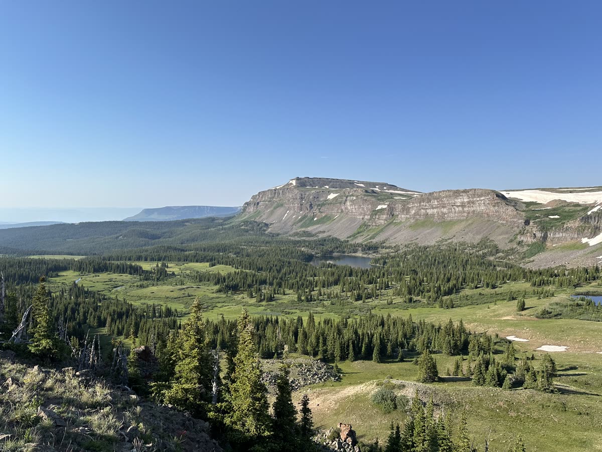 Wide green valley below the cliffs of a flat-topped mountain